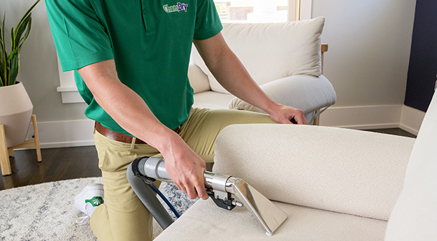 technician cleans upholstery on furniture
